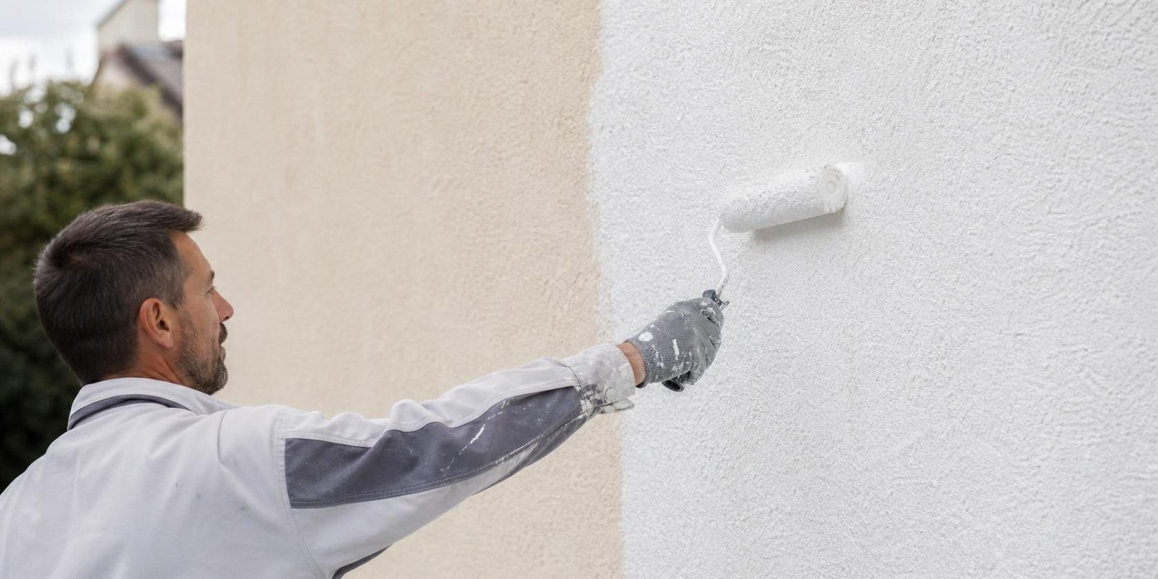 Application d’une sous-couche façade au rouleau sur un mur extérieur | Artihome Artisan appliquant une sous-couche façade au rouleau sur un mur extérieur avant peinture